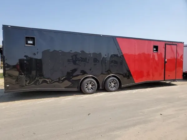 Black and red car hauler with a V-nose, side view