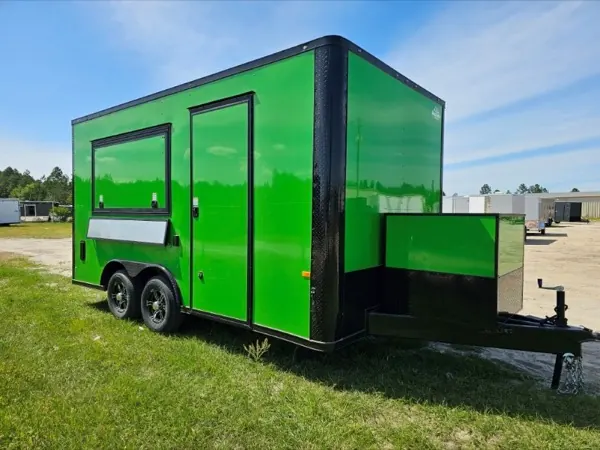 Green concession trailer with a serving window and a black deck on the tongue