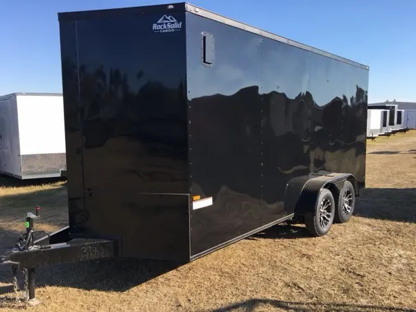 Black tandem axle cargo trailer with the Rock Solid Cargo decal, front three-quarter view