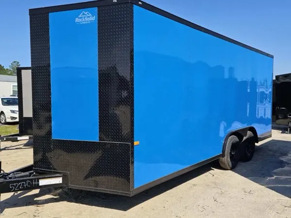 Bright blue tandem axle cargo trailer with black trim and a diamond plate front, side view