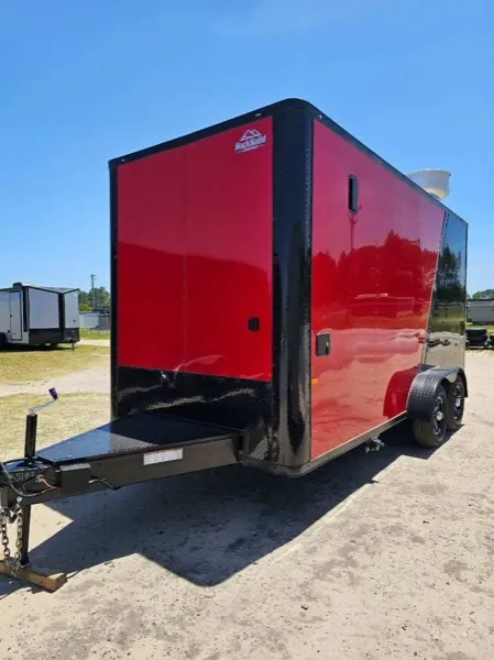 Red tandem axle cargo trailer with black trim and fenders, front three-quarter view